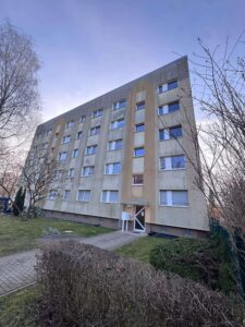 Immobilienverwalter prüft den Zustand einer Fassade als Grundlage für eine notwendige Fassadenreinigung.